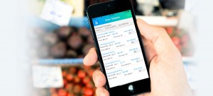 Sales rep holding a phone infront of some diferent produce, using a sales rep software to create an invoice using a digital invoice template