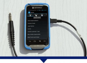 A Motorola TC55 with a mobile invoice software installed, connected to a DEX Cable to transfer invoices